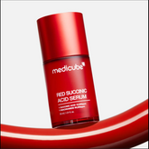 Red succinic acid serum bottle with Medicube branding on a white background