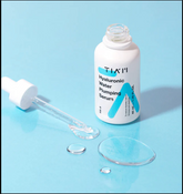 TIAM Hyaluronic Water Plumping Serum 50ml white bottle with dropper on blue background