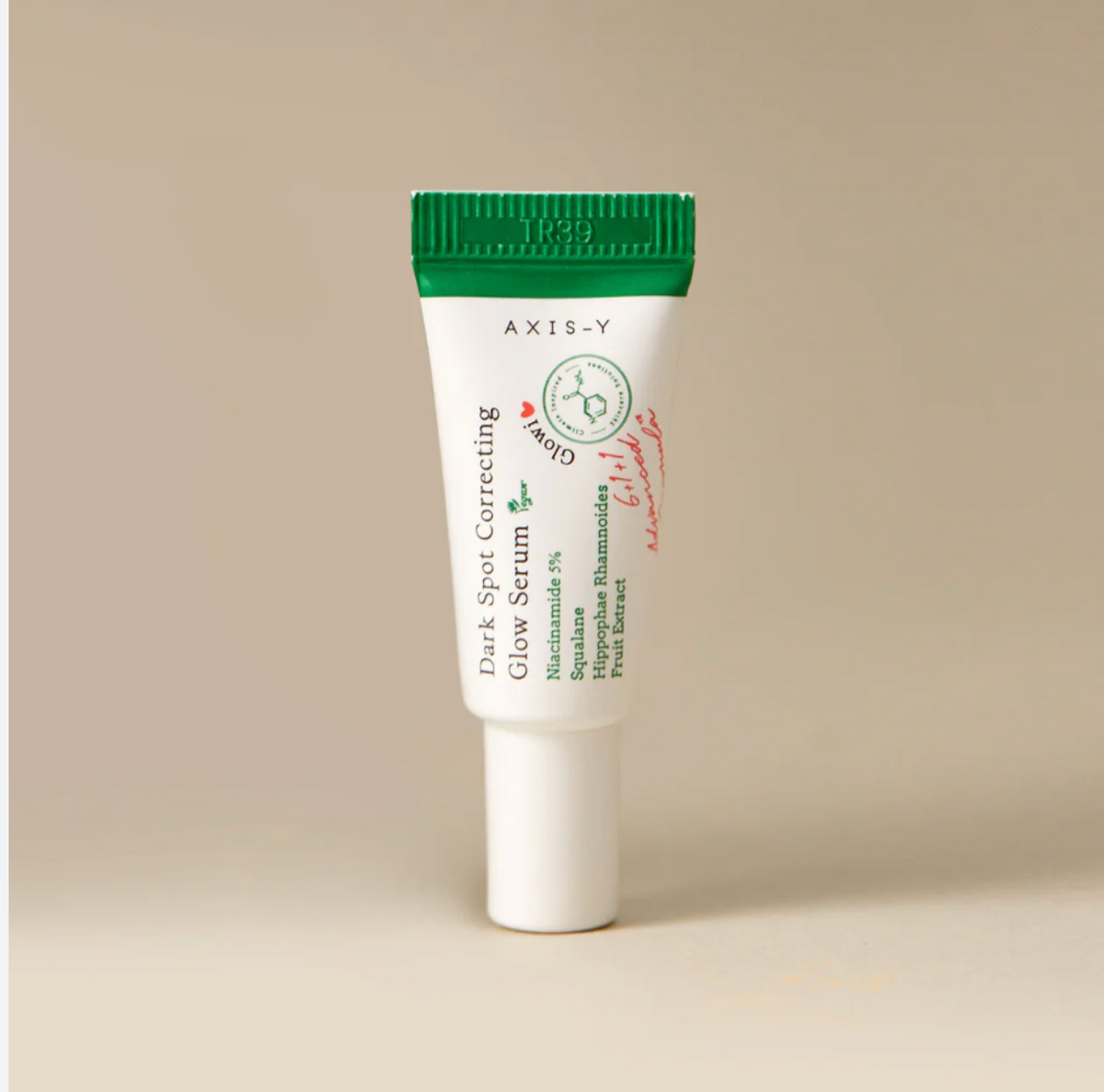AXIS-Y Dark Spot Correcting Glow Serum 5ml mini tube with green cap on beige background