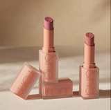 Lipstick with open case on a beige background
